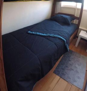 a bed with a blue comforter in a room at Habitación privada con camarote en departamento compartido - Providencia in Santiago
