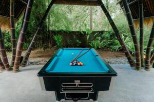 Una mesa de billar con bolas encima en Jungle House Estate, en Gianyar