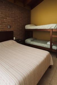 a room with two bunk beds and a brick wall at Tu refugio en Miramar con pileta y parrilla in Miramar