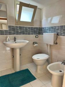 a bathroom with a sink and a toilet and a mirror at Marzamemi Da Giusy in Pachino