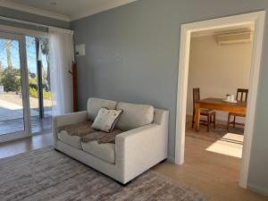 アシュバートンにあるRevive On Oakview Boutique Beauty and Accommodationのソファとテーブルのあるリビングルーム