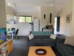 a living room with a couch and a table at Beachside Haven Free Linen Wi-Fi Netflix air con in Boomerang Beach +36 photos