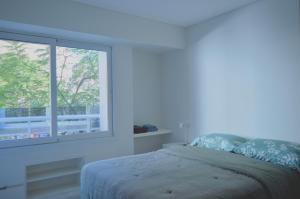 ロサリオにあるDepto Minercoのベッドと窓のある白い寝室