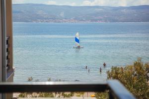 un velero en el agua en una playa en Apartments Sea View, en Omiš