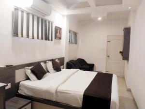 a bedroom with a bed and a chair in it at Amber Residency in Ernakulam