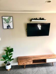 a living room with a tv on a wall at 3 Bedroom Apartment next to Blake Park in Mount Maunganui