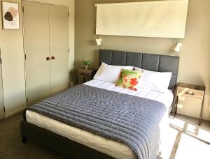 a bedroom with a large bed with a blue blanket at 3 Bedroom Apartment next to Blake Park in Mount Maunganui