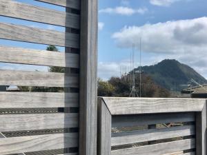 a wooden fence with a view of a mountain at 3 Bedroom Apartment next to Blake Park in Mount Maunganui