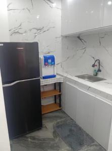 a kitchen with a black refrigerator and a sink at elisatransienthouse in Labac