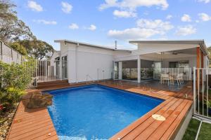 a house with a swimming pool and a wooden deck at The Palm House - Cowes in Cowes