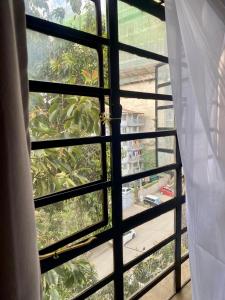 a window with a view of a garden outside at Furnished Studio Apartment in Nairobi West in Nairobi