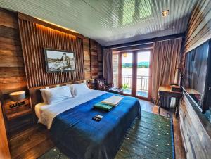 a bedroom with a large bed and a television at Suneta Hotel Chiangkhan Soi 6 in Chiang Khan