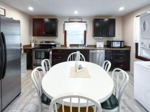 a kitchen with a white table and white appliances at Lake Huron Getaway by arc Vacation Rentals in Lexington