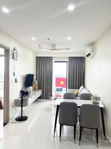 ein weißes Wohnzimmer mit Tisch und Stühlen in der Unterkunft New Moon homestay- Nera garden Huế in Thôn Văn Dương