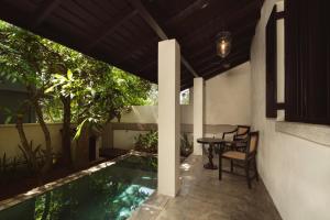 a patio with a pool and a table and chairs at Beldon Boutique Hotel in Hiriketiya