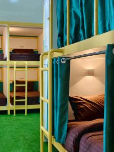 2 stapelbedden in een kamer met groen tapijt bij Banana Bunkhouse Hostel in Rawai Beach