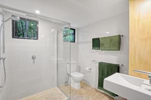 a bathroom with a shower and a toilet and a sink at Pandanus Retreat in Point Lookout +16 photos