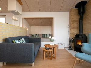 ein Wohnzimmer mit Sofa und Kamin in der Unterkunft 4 star holiday home in Frørup in Frørup