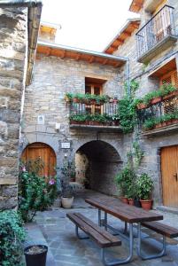 un edificio de piedra con una mesa de picnic delante de él en Casa Encuentra, en el Pirineo al lado de Ainsa, en El Pueyo de Araguás