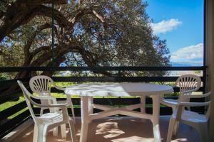 a table and chairs on a porch with a tree at Apartments Sea View in Omiš
