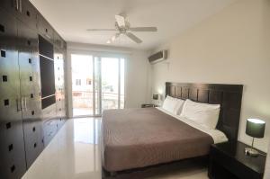 a bedroom with a bed and a ceiling fan at Phenomenal Location Near Beach & 5th with Stunning Roof Pool in Playa del Carmen +12 photos