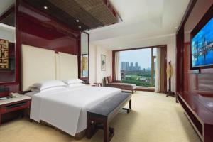 a bedroom with a large white bed and a large window at Wuhan Gaotie Kairui International Hotel in Wuhan +178 photos