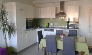 a kitchen with white cabinets and a table with chairs at Apartment Mery in Trogir +14 photos