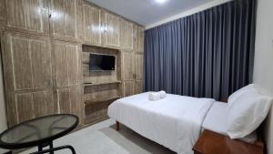a bedroom with a bed and a chair and a television at Huis TANTI Homestay Jember in Wirolegi