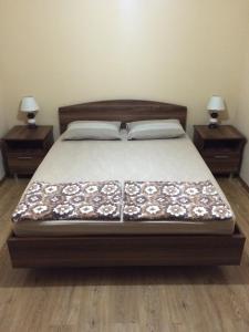 ein Schlafzimmer mit einem Bett mit zwei Nachttischen und zwei Tischen in der Unterkunft Mari Guest House in Telawi