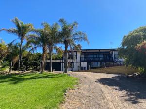 Un edificio con palmeras frente a un camino de tierra. en Lakefront Palms, en Bonnie Doon