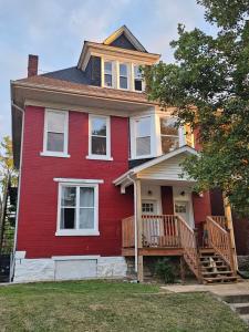a red house with a porch and a deck at Maple Manor Private in Saint Louis