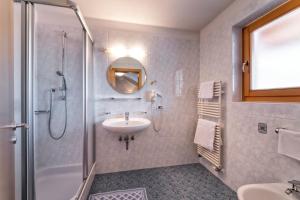 y baño blanco con lavabo y ducha. en Hotel Elisabeth en Chienes