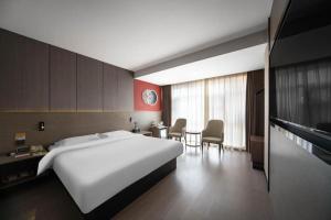 Una habitación de hotel con una gran cama blanca y una mesa. en Jinjiang Inn Select Xi'an Hongmiaopo East Daxing Road, en Xi'an 161 fotos más