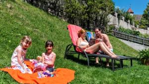 eine Gruppe von Menschen, die im Gras sitzen in der Unterkunft Hotel Elisabeth in Kiens