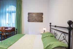 a bedroom with a bed with green sheets and a window at B&B Casa Cavour in San Benedetto del Tronto