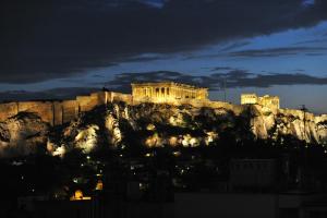 a building on top of a mountain at night at Pergamos Hotel in Athens