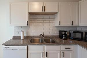 a kitchen with a sink and a microwave at Spacious 4BR Family Home in Detroit WiFi Parking in Detroit +21 photos