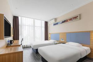 a hotel room with three beds and a television at City Comfort Inn Wuhan Dongwu Avenue Light Rail Station in Wuhan