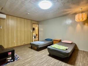 una habitación con dos camas y un sofá en coco house, en Ishigaki Island