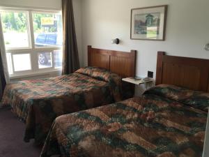 Habitación de hotel con 2 camas y ventana en Pleasant Manor Motel, en Collingwood