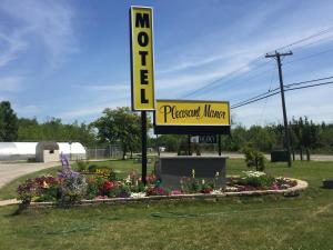 a sign for a massage house with flowers in a garden at Pleasant Manor Motel in Collingwood