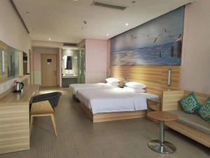 a bedroom with two beds and a large painting on the wall at City Comfort Inn Jingzhou Railway Station Fantawild in Caoshi +182 photos