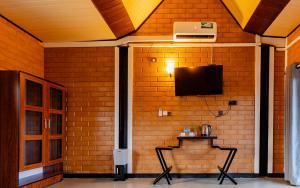 a room with a wall with a tv and two chairs at waasala transit hotel in Ja-Ela