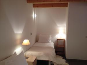 a small bedroom with a white bed and two lamps at Lakeview 180° in Talloires