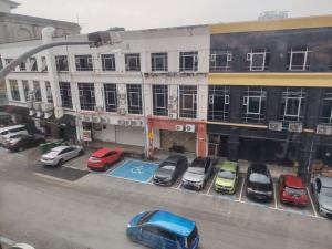 a parking lot with cars parked in front of a building at Kozi Hotel - Bukit Indah in Johor Bahru