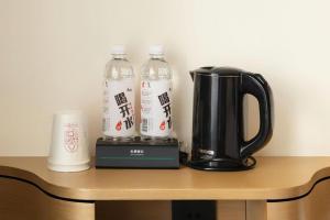 zwei Flaschen Wasser und eine Kaffeemaschine auf einem Tisch in der Unterkunft City Comfort Inn Foshan Gaoming Huaying Square in Shilong