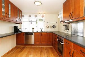 a kitchen with wooden cabinets and stainless steel appliances at Mandal Privat Rom og husutleie in Mandal