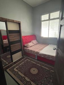 a small room with a bed and a window at CILI PADI GUESTHOUSE in Kota Bharu