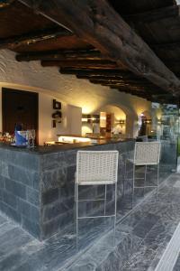 a bar with two white chairs and a counter at Hotel Boutique Ses Pitreras in San Antonio Bay