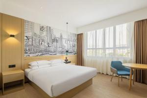 a hotel room with a bed and a desk and a table at City Comfort Inn Maoming Xinyi Donghuicheng in Xinyi